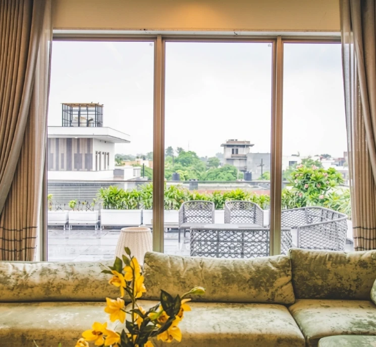 Modern room interior view of green velvet sofa and city terrace